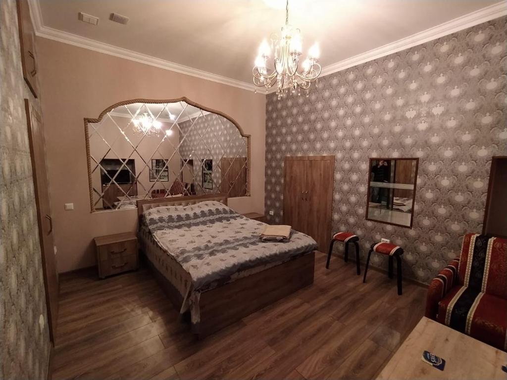 巴库apartament oriental tale in old cyti Baku的一间卧室配有一张大床和一个吊灯。