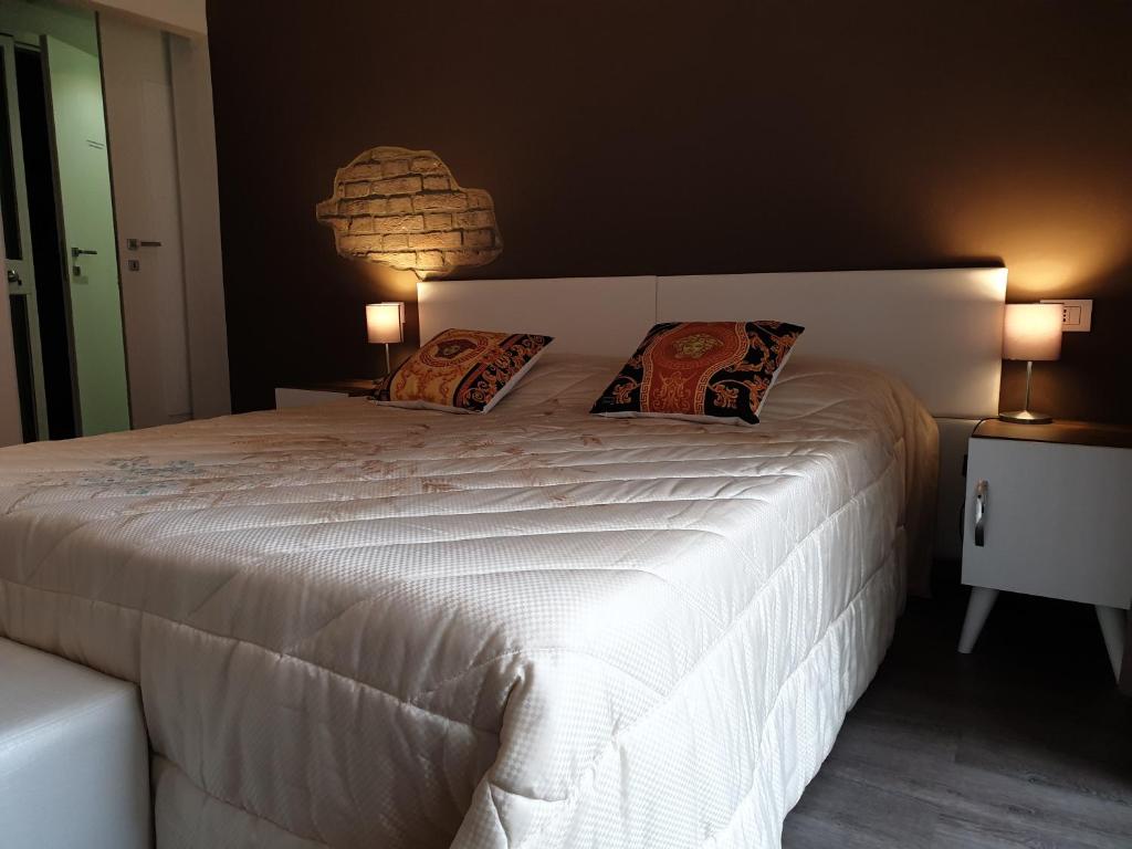 帕尔马ForumGuestHouse Center Parking的卧室配有一张带两个枕头的大白色床