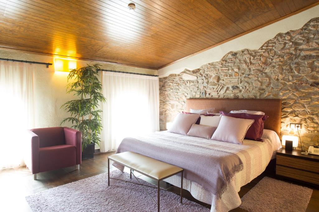 博特阿瑞尔卡尔巴贝尔酒店的一间卧室设有一张带石墙的大床