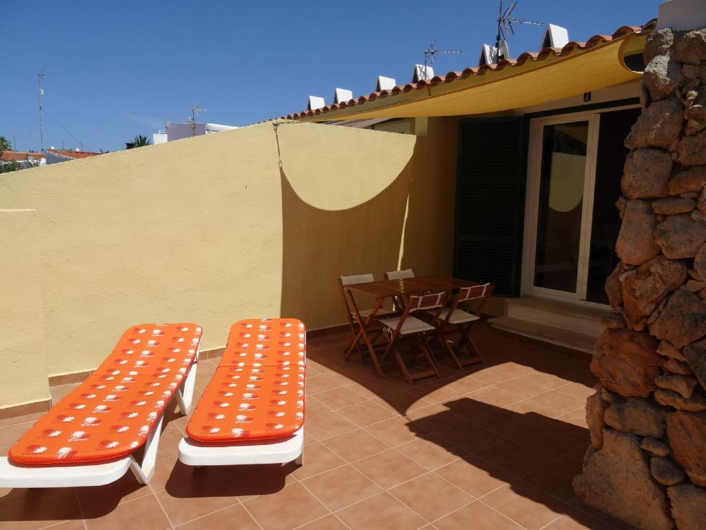 卡拉恩·布拉內斯Apartamento las Siete Palmeras的庭院里的一个橙色和白色的长凳和一张桌子
