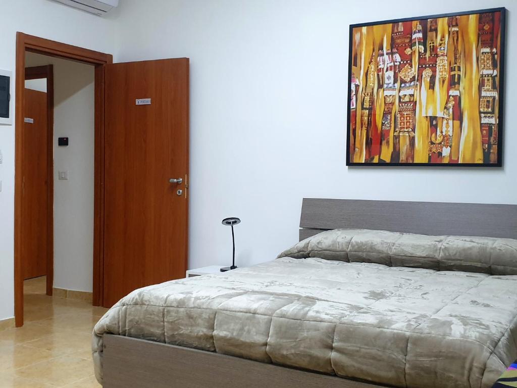埃尔科拉诺B&B HERCULANEUM RUINS的卧室配有一张床,墙上挂有绘画作品