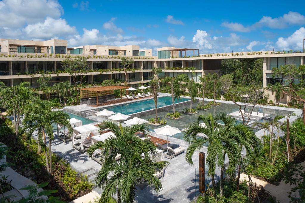 图卢姆MISTIQ Tulum Luxury Apartments的一个带游泳池和棕榈树的度假村