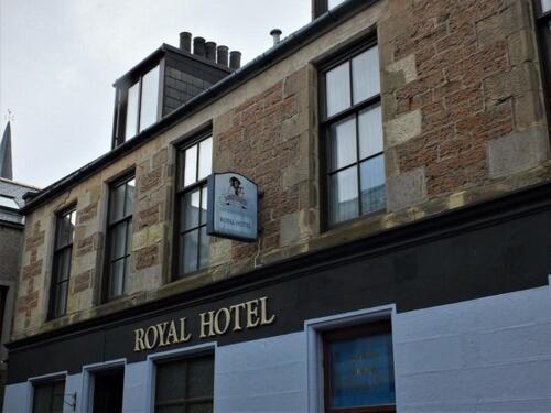 斯特罗姆内斯The Royal Hotel的砖砌建筑,上面有酒店标志