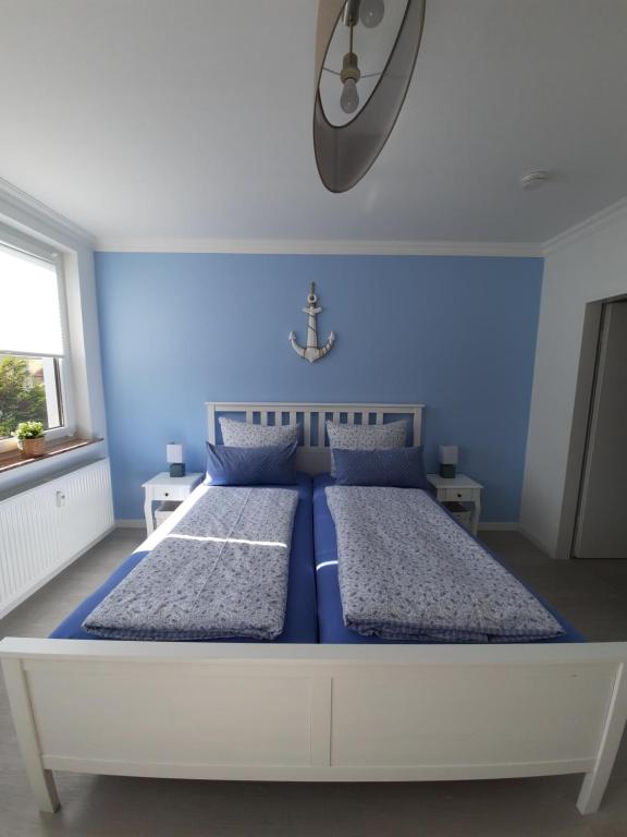 不来梅港Ferienwohnung Seestern 61的蓝色卧室设有一张带蓝色墙壁的大床