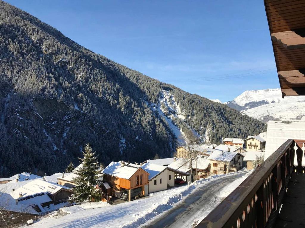 佩塞克鲁瓦Chalet de 3 chambres a Peisey Nancroix a 500 m des pistes avec terrasse et wifi的一座雪覆盖的村庄,后面有一座山