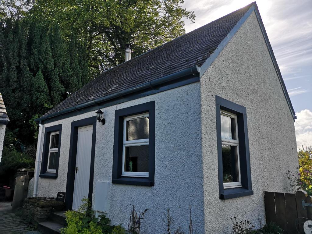 BuchlyviePrivate Cottage Bothy near Loch Lomond & Stirling的一间设有两扇窗户和屋顶的小房子