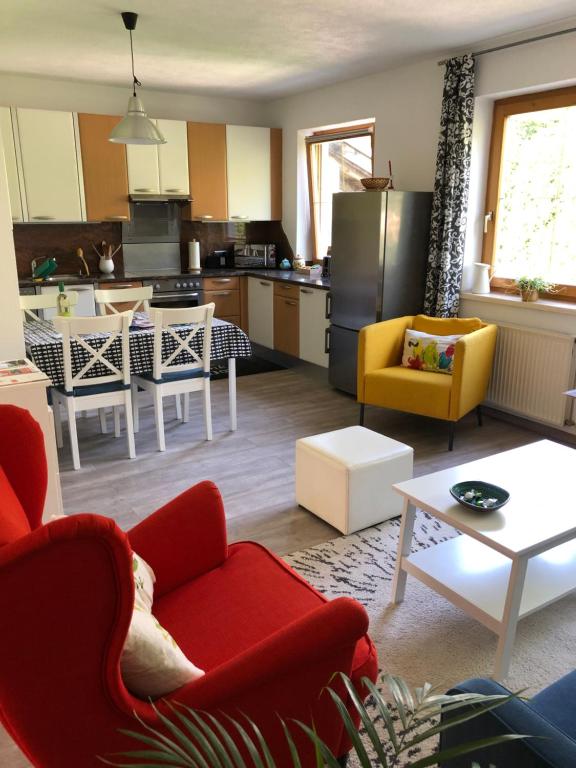 因斯布鲁克Apartment Ida的一间带红色椅子的客厅和一间厨房