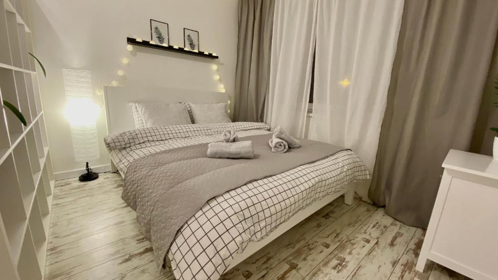 陶格夫匹尔斯Cosy&White apartment in Daugavpils的一间卧室配有一张床,上面有两条毛巾
