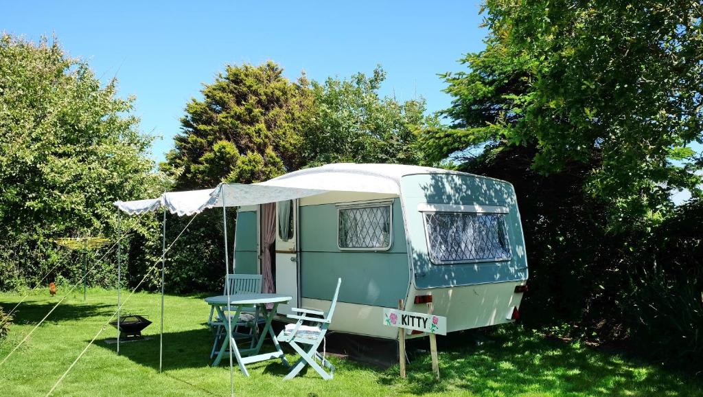 利扎尔德KItty unique 60s caravan set in pretty garden的绿色大篷车,配有桌子和帐篷