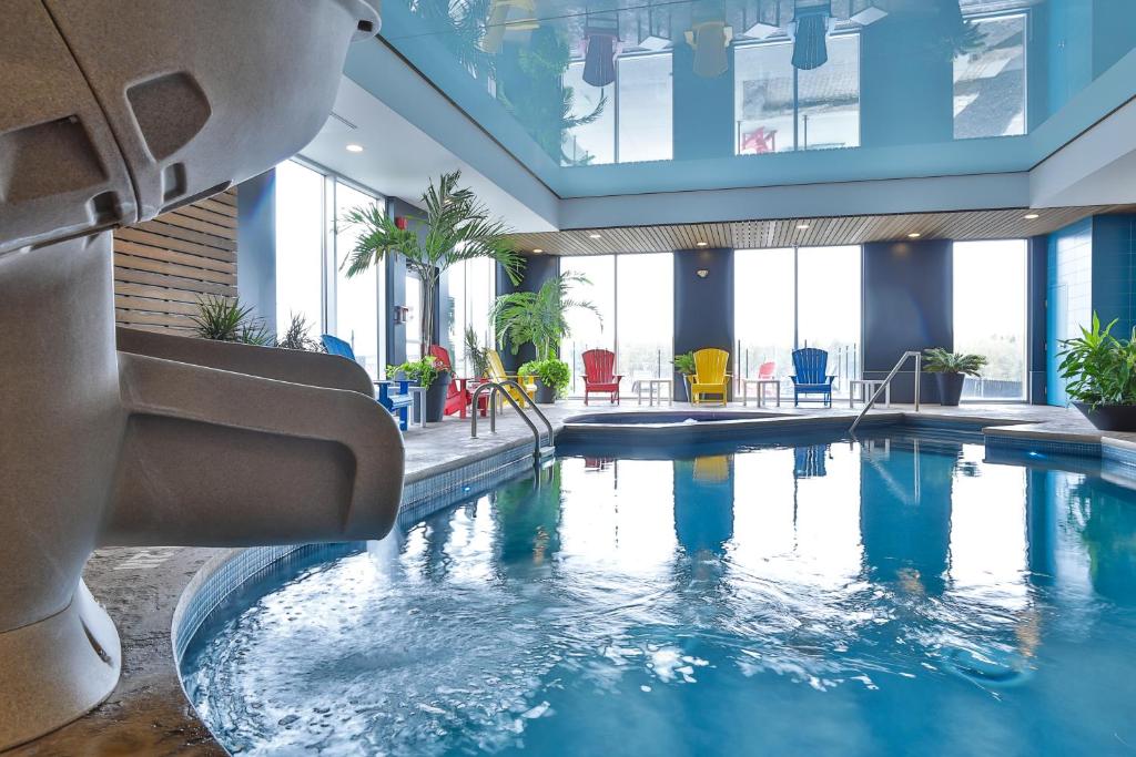 圣热罗姆圣杰罗姆康福特茵酒店的一座大型游泳池,位于一座带窗户的建筑内