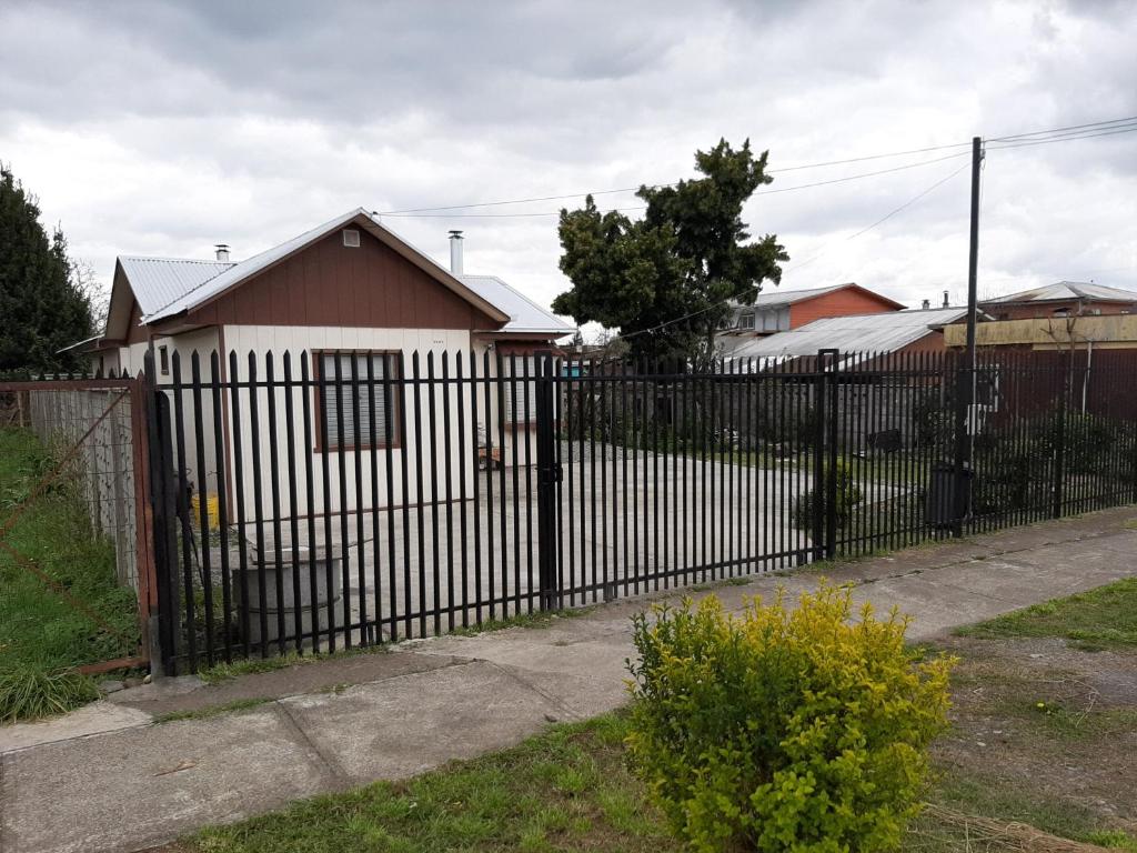 PitrufquénCabaña centro Pitrufquen的房屋前的黑色围栏