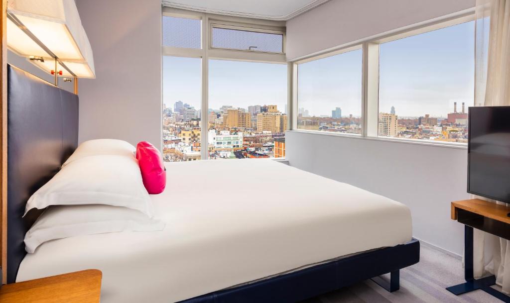 纽约东乡村设计酒店的一间卧室设有一张床和一个大窗户