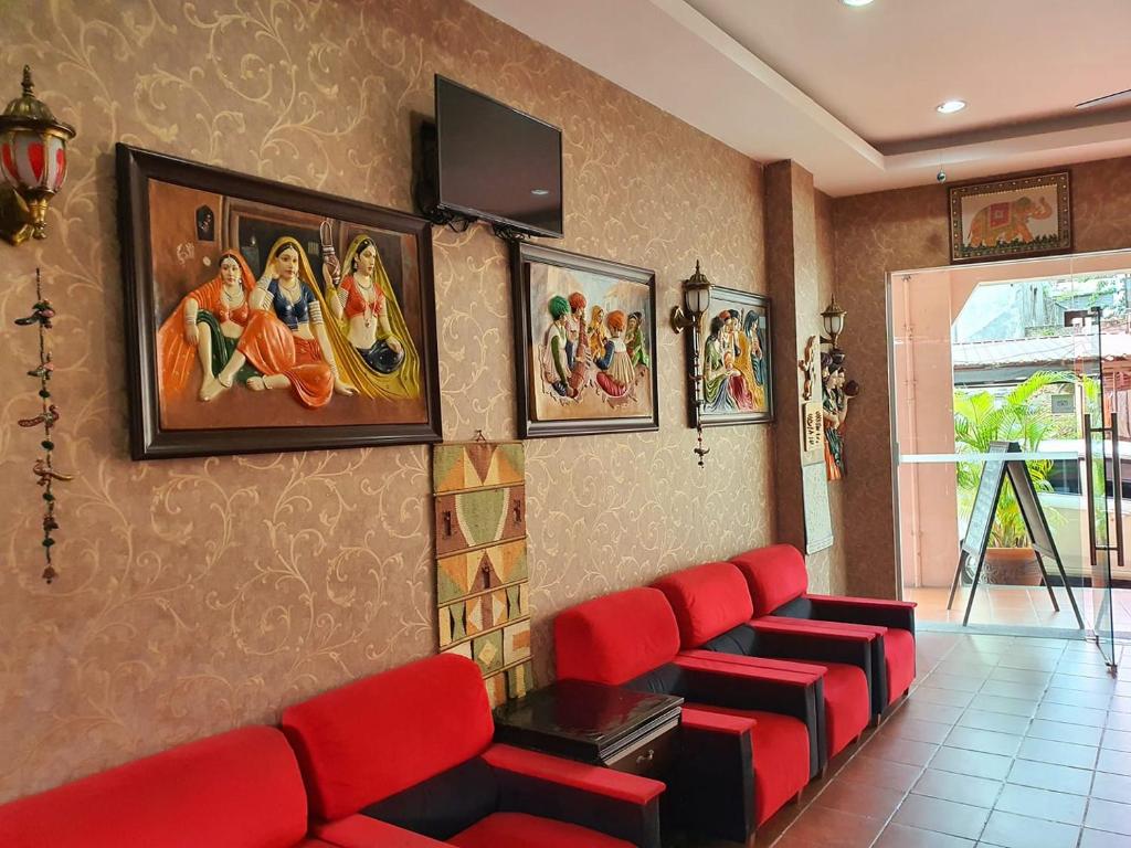 乔治市小印度传统别墅酒店的一间设有红色椅子和壁画的等候室