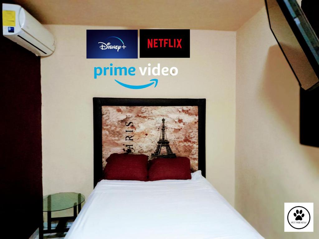 切图马尔Relax Home Aeropuerto-Tren Maya的一张带红色枕头的床和黄金视频标志