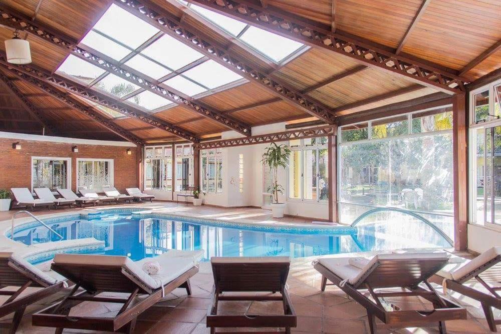 费德拉西翁Costa Del Sol的室内游泳池,设有玻璃天花板温室