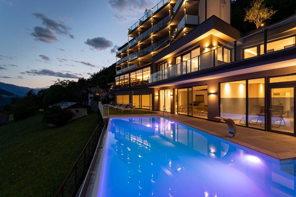 蒂鲁罗Hotel Lechner的一座晚上设有游泳池的房子