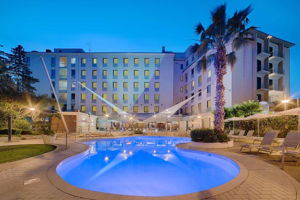 巴勒莫NH巴勒莫酒店的棕榈树酒店前的游泳池