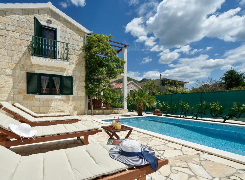 奥米什Villa Josip near Omiš , private pool的一个带游泳池和房子的后院