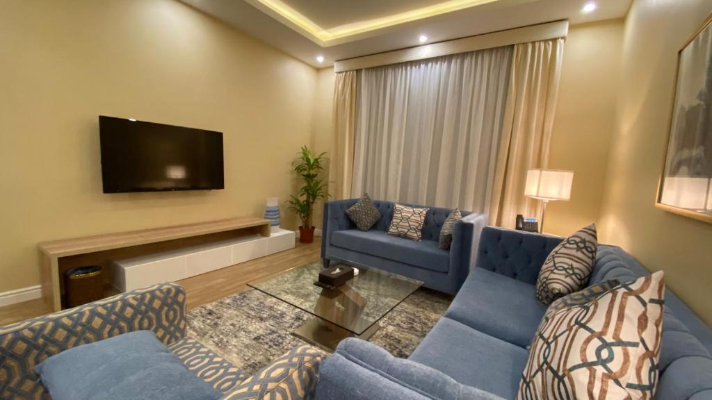 吉达ماس للشقق الفندقية الفاخرة的客厅配有蓝色的沙发和平面电视。