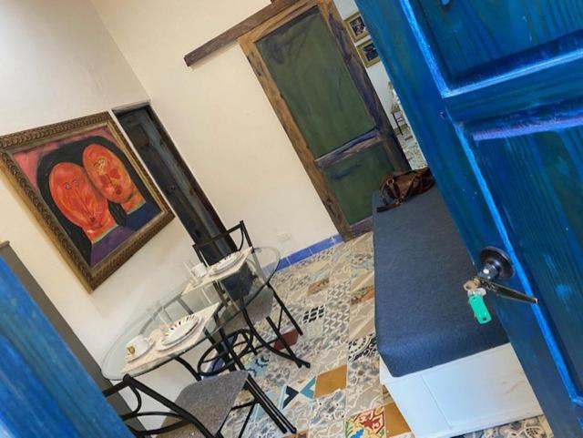 圣多明各Chao Mamá Hostal的一间设有蓝色门、一张桌子和椅子的房间