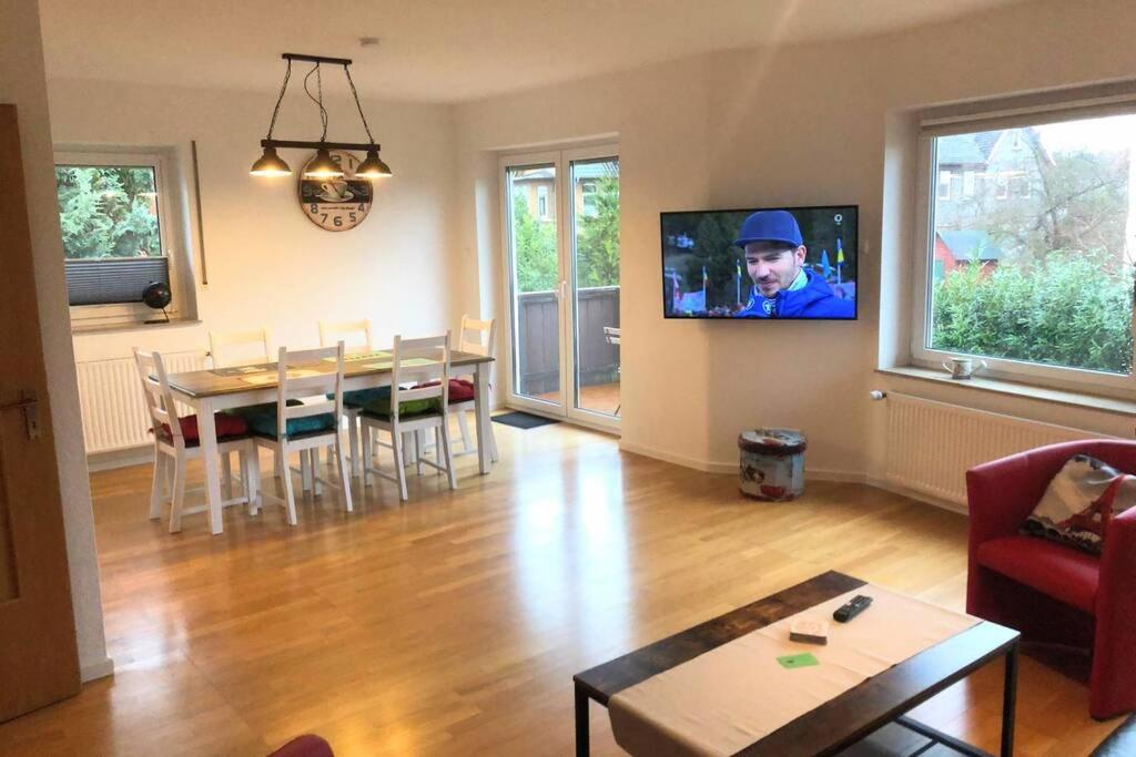 艾恩贝克EXKLUSIVE Ferienwohnung in Einbeck, 3 Schlafzimmer mit Balkon!的客厅配有桌子和墙上的电视