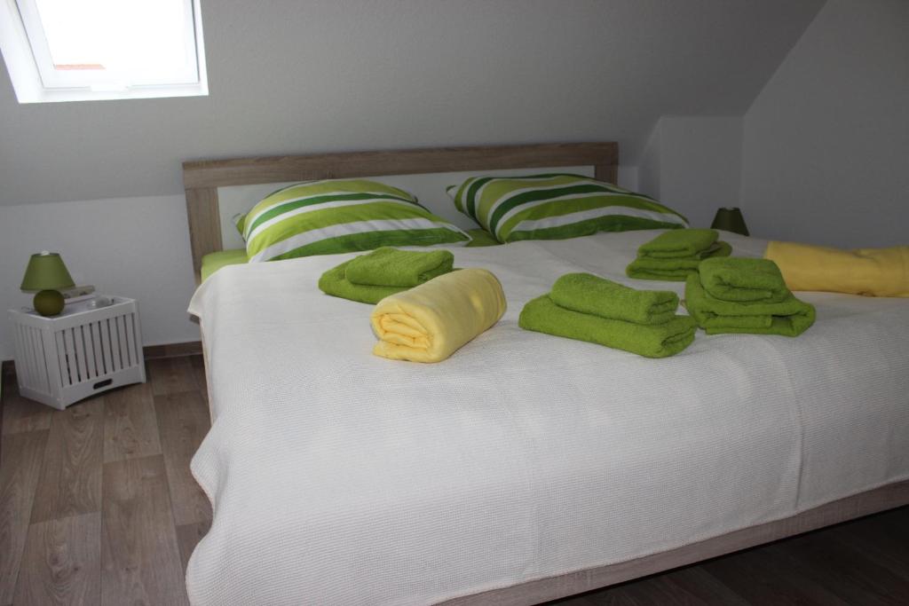 奎德林堡Ferienhaus Brücke的一张带绿色毛巾和枕头的床