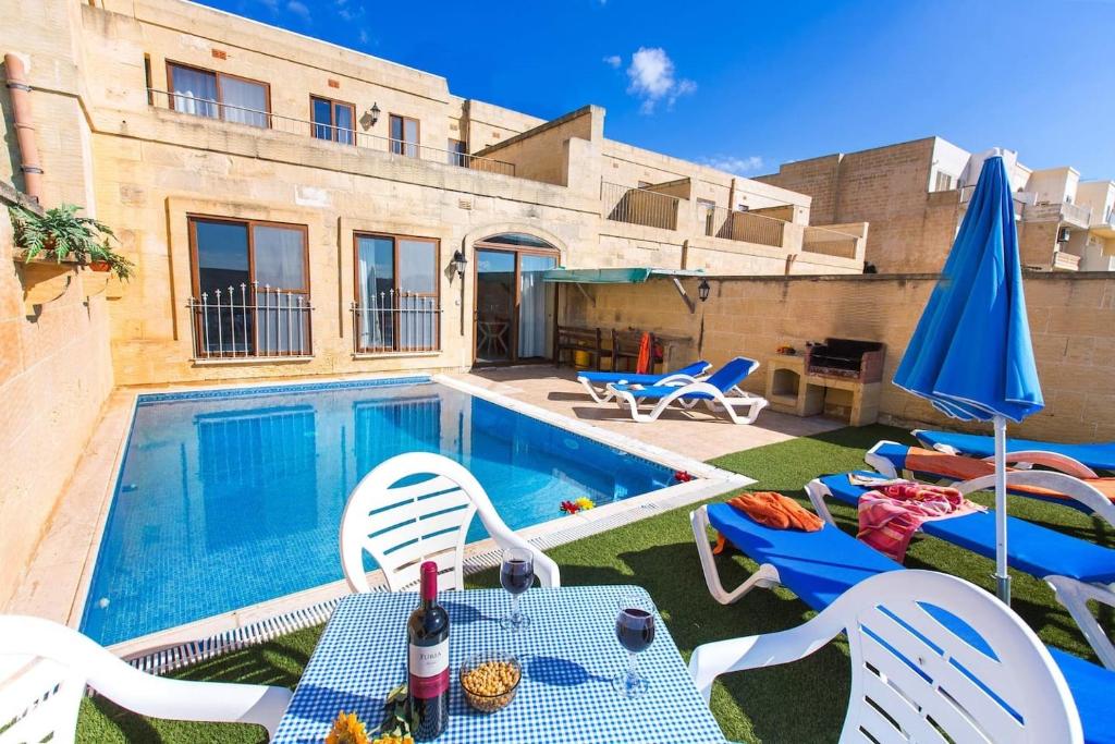 沙拉Ta Danjela 4 bedroom Villa with private pool的游泳池配有椅子、桌子和遮阳伞
