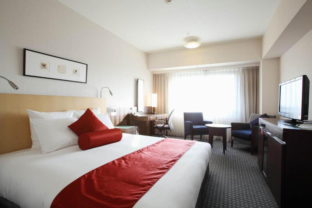 成田成田全日空皇冠假日酒店的酒店客房,配有床和电视