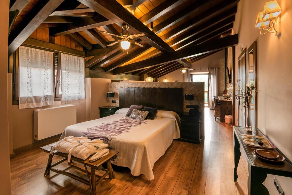 Ziga阿尔德克阿乡村旅馆的一间带一张大床的卧室,位于一个拥有木制天花板的房间