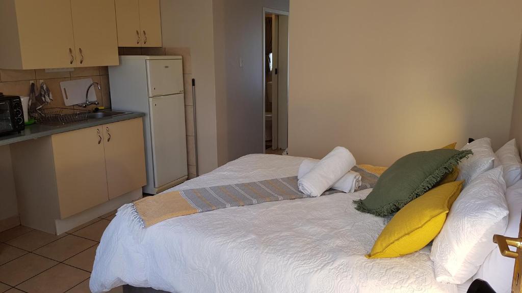 比勒陀利亚Accommodation@Park1285的卧室配有白色的床和枕头。