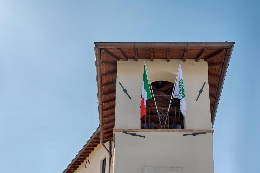 San Demetrio neʼ VestiniResidenza Cappelli - Affittacamere的建筑物一侧有两面旗帜的塔楼