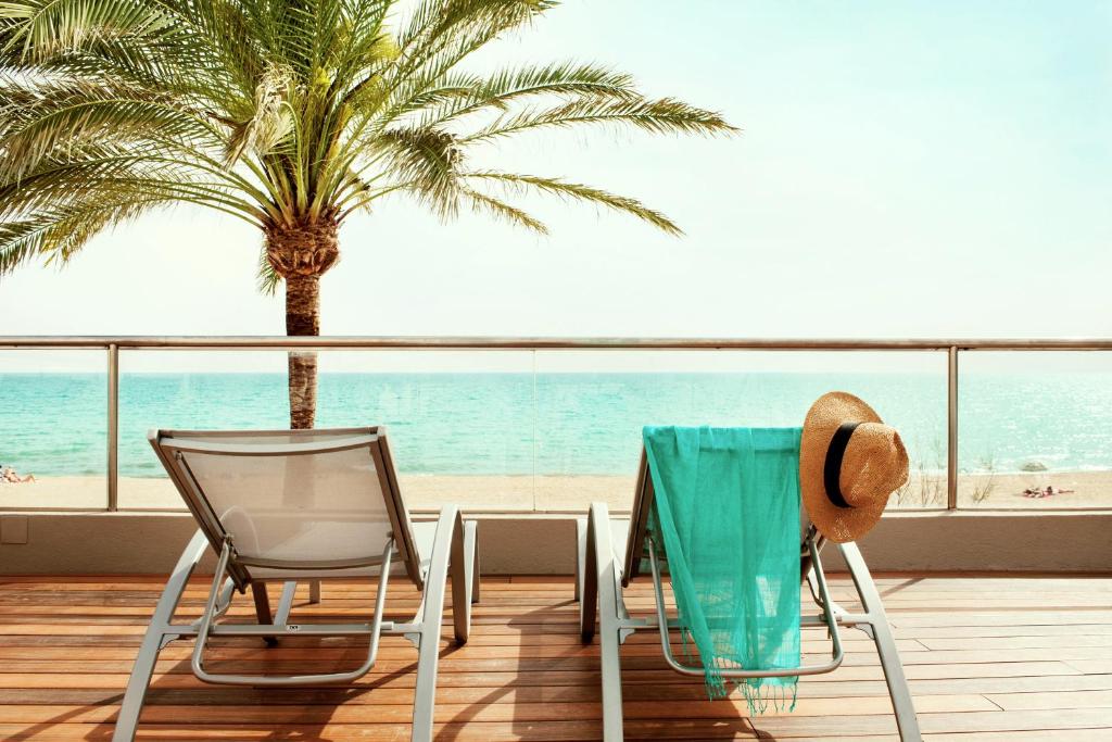 坎帕斯蒂利亚PALMA BEACH HOTEL Adults Only的海滩景阳台配有桌椅