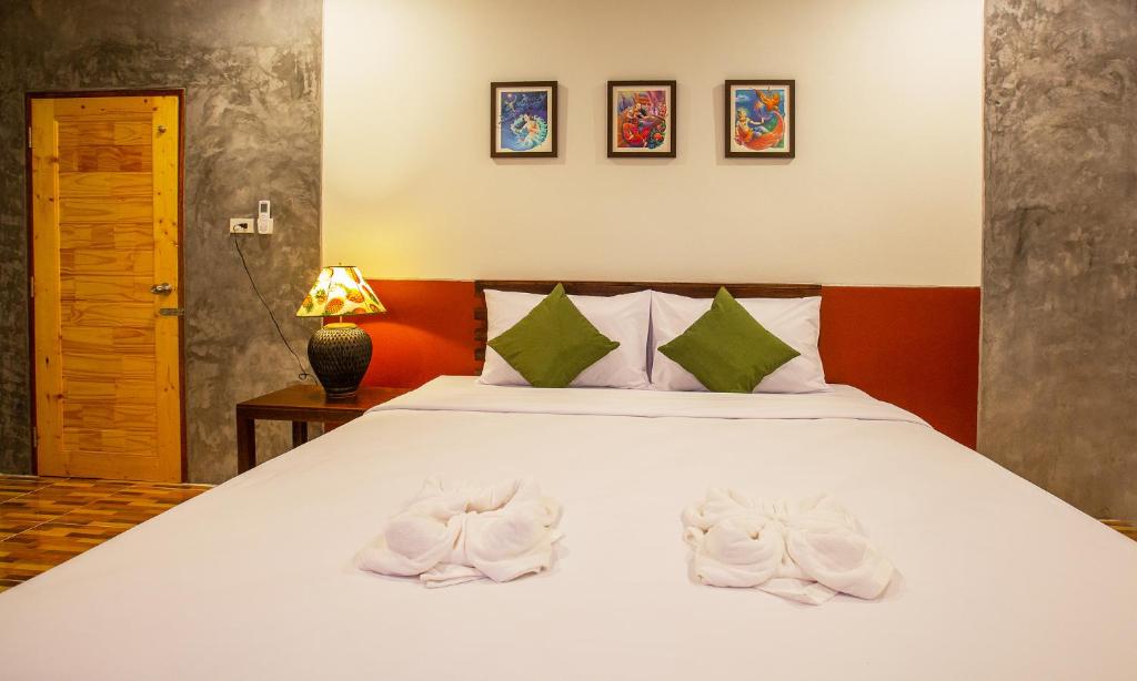 攀牙府Phangnga Keeree Resort & Gallery的一间卧室配有一张带白色毛巾的床