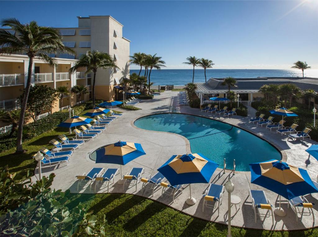 布卡拉顿海滨市奥欣赛德海滩假日酒店的享有带遮阳伞的游泳池和大海的顶部景致