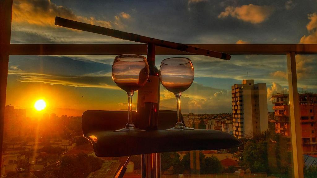 圣卡洛斯VIKINGS- Alto Padrão, Apto Rústico com conforto,Wifi e vista incrivel máx 4的两杯酒坐在窗前的桌子上
