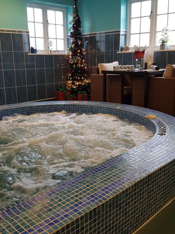 迪尔Igguldene Retreat with Jacuzzi的客房内的按摩浴缸,配有圣诞树