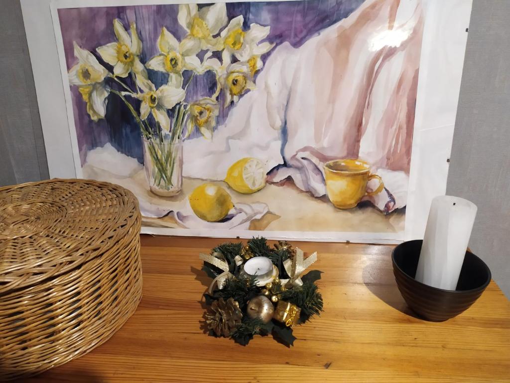 罗夫诺Апартаменти Світлий Ранок та Затишний Вечір的一张桌子,上面放着蜡烛和鲜花,还有一幅画