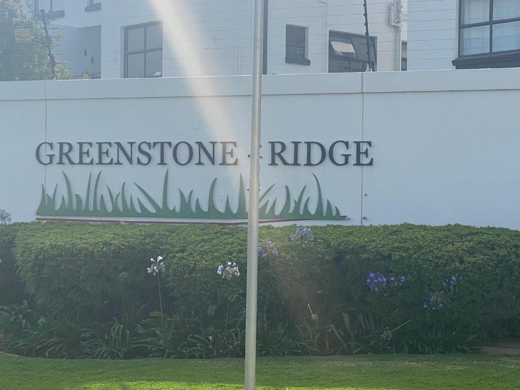 约翰内斯堡Greenstone Ridge Apartment的建筑前的绿石脊的标志