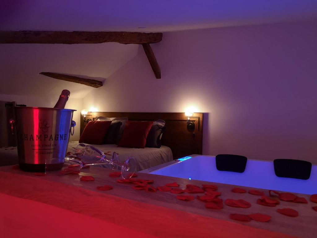 Pont-de-VeyleEscapade Veyloise-Nuit romantique-Spa-Champagne的一间设有床铺的客房,配有一个装满玫瑰的浴缸