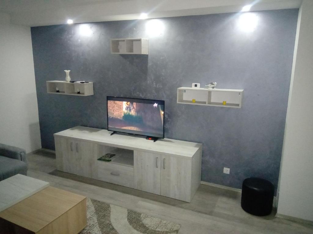 巴伊纳巴什塔Fantastik的一间客厅,客厅的蓝色墙壁上配有电视
