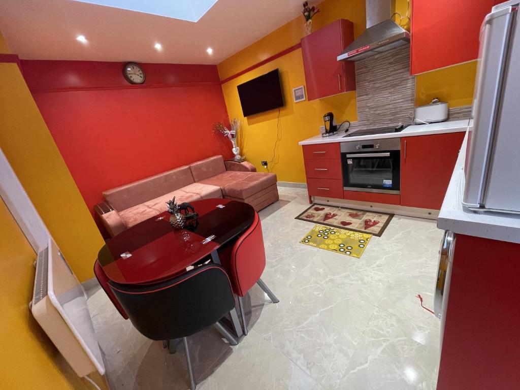 哈罗Modern Garden House的一间厨房,拥有红色和黄色的墙壁和一张沙发