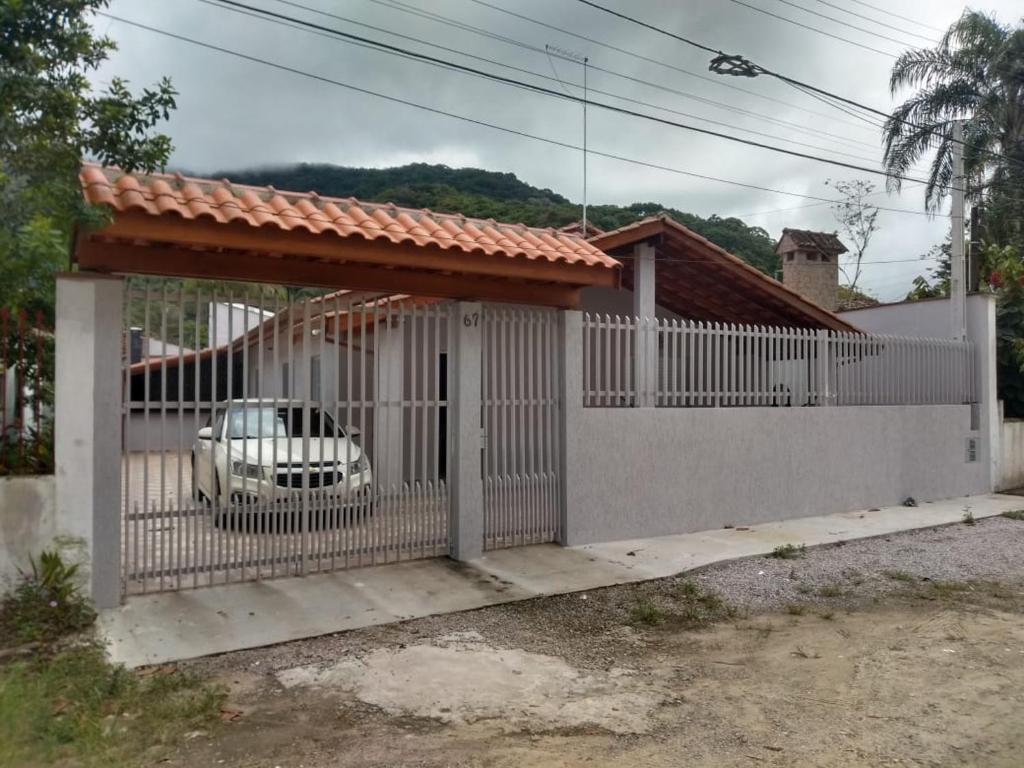 乌巴图巴Casa Ubatuba Perequê Açu的白色的围栏,里面装有汽车