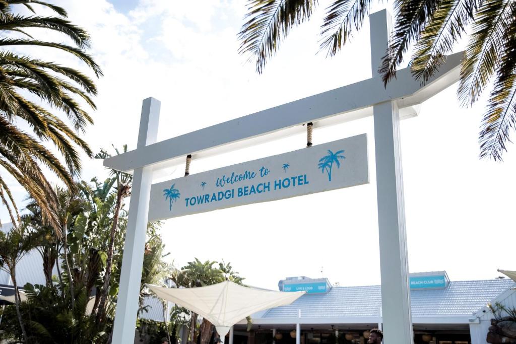 卧龙岗托拉吉海滩康福特茵酒店的椰林海滩酒店标志