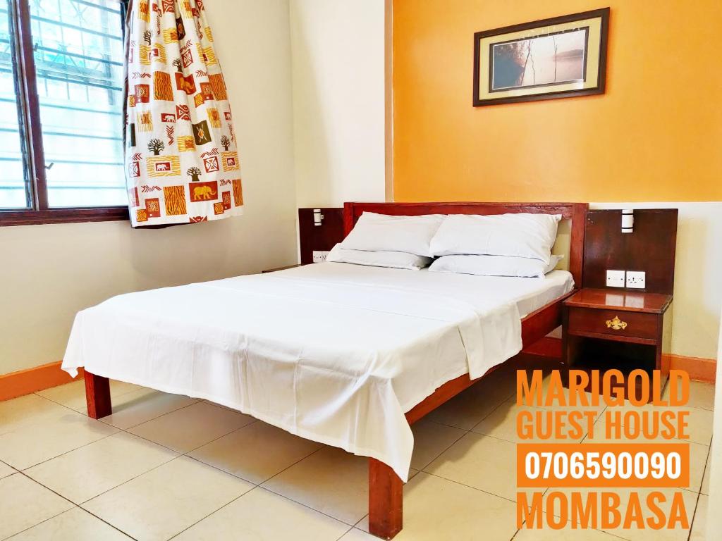 蒙巴萨Marigold Guest House的一间带床的卧室,位于带窗户的房间内