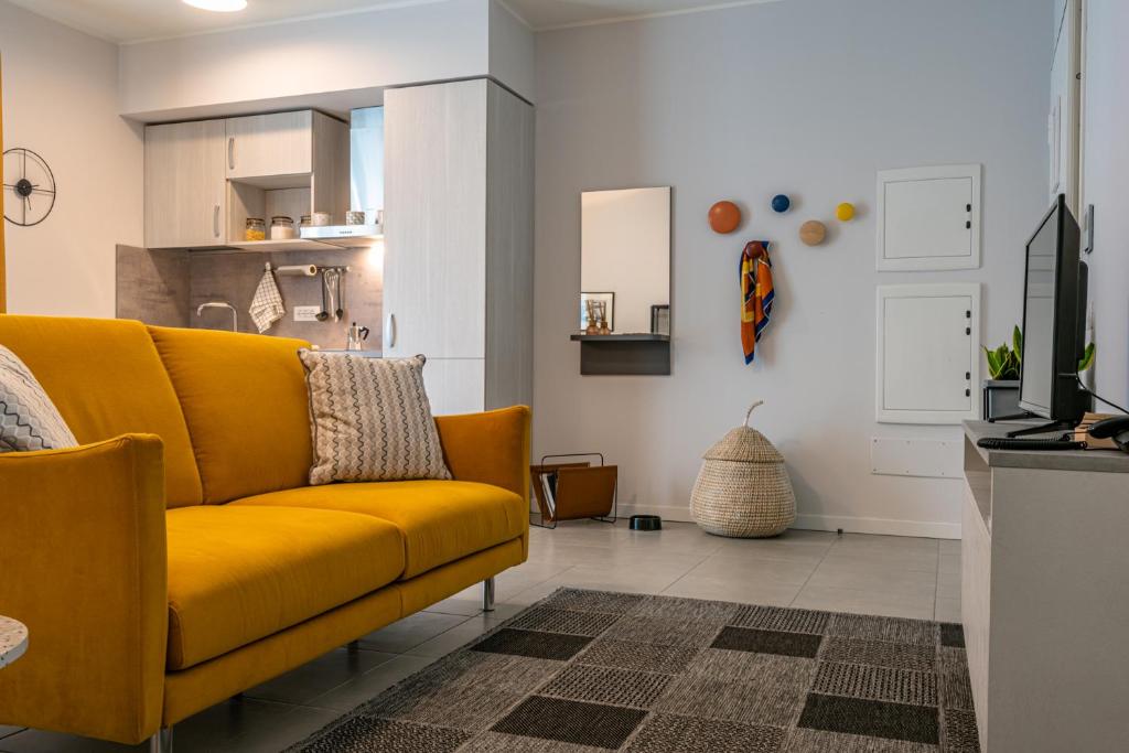 贝加莫Domitys Quarto Verde的一间带黄色沙发的客厅和一间厨房
