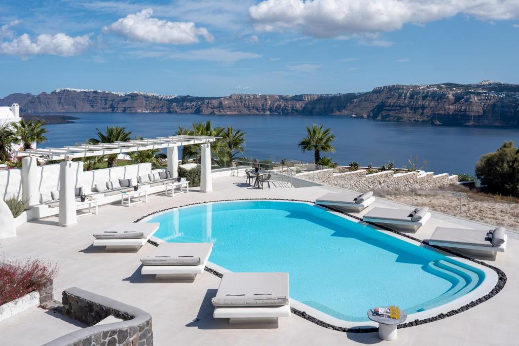 阿克罗蒂里火山口元素套房旅馆的一个带椅子的游泳池,享有水景