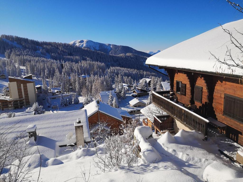 瓦尔堡Appartement La Croix Saint Jean Valberg的一座被雪覆盖的建筑,背景是群山