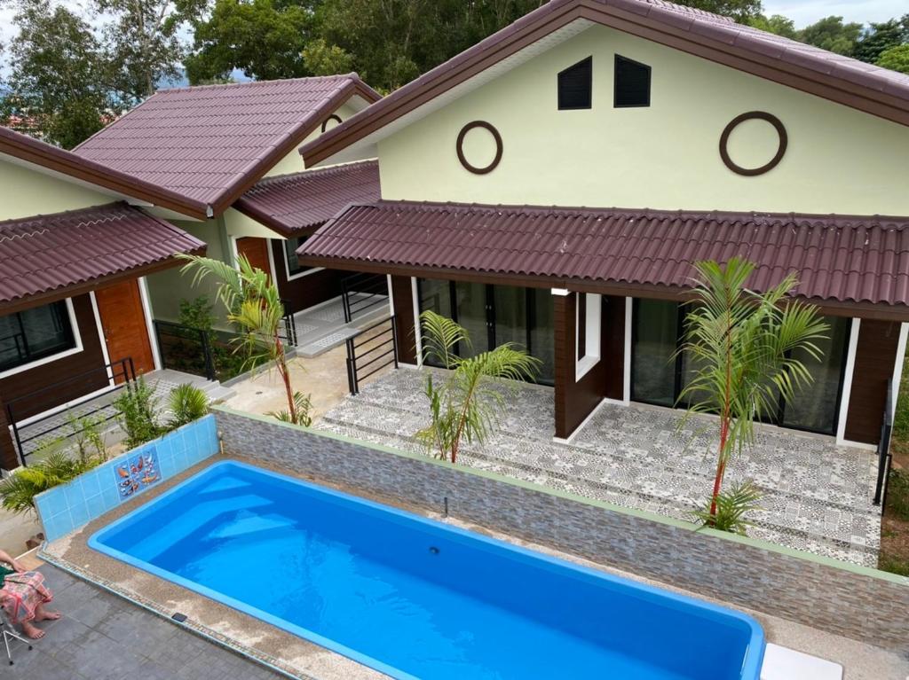 沙敦Piumsuk Villa的前面有一个蓝色游泳池的房子
