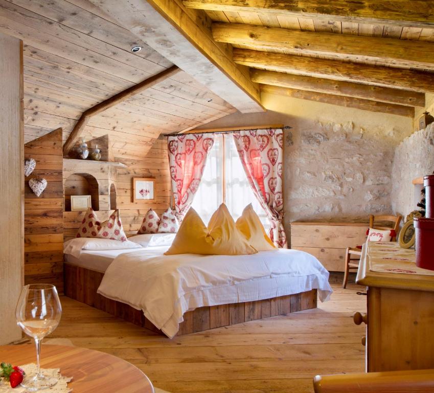 NembiaChalet Sogno di Fiaba的一间带一张床的卧室,位于带木制天花板的房间内