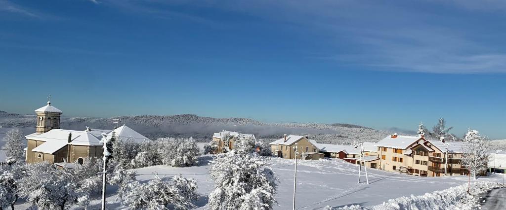 Giron勒瑞莱斯诺迪克宾馆的一座被雪覆盖的城镇,一座建筑和一座教堂